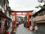 Ворота Torii, указывающие путь к святилищу, начинаются на городской торговой улочке.